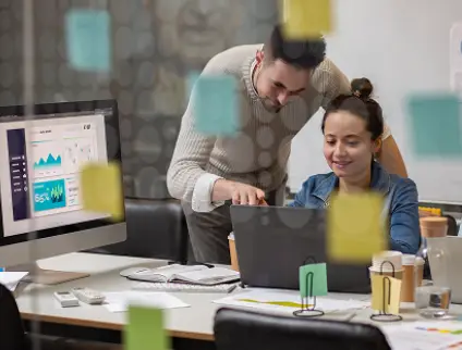 Digital agency team reviewing project work on a laptop